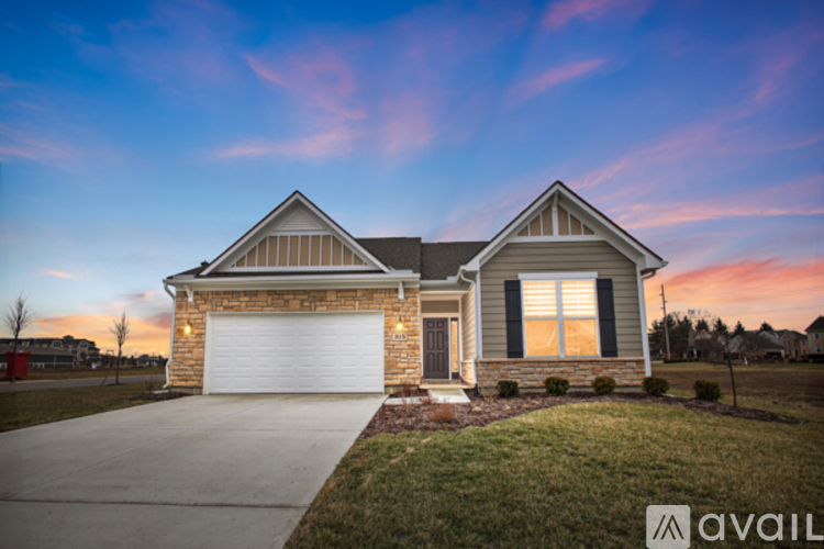 A house with a garage and a driveway is available for sale.