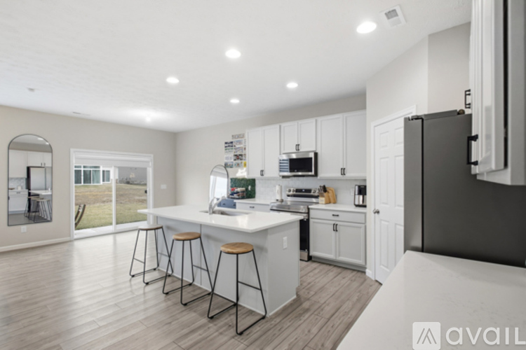 A modern kitchen with white cabinets and a large island.