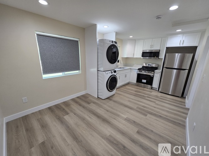 A kitchen with a washing machine and a refrigerator.