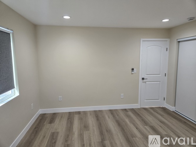 A room with wooden flooring and white walls.