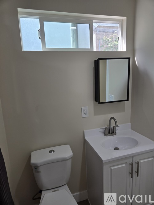 A white toilet sits next to a sink in a bathroom.