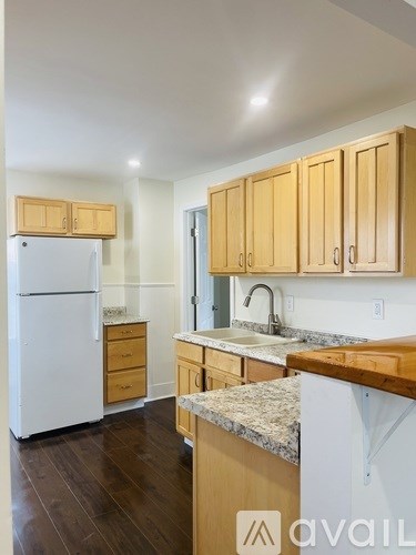 A kitchen with wooden cabinets and a white refrigerator.