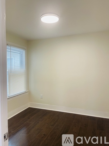 A room with a window and wooden floors.