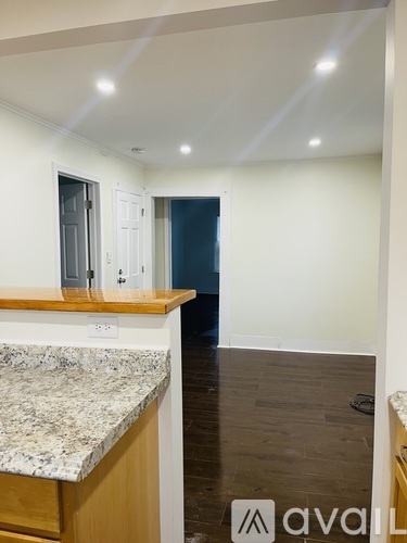 A kitchen with a granite countertop and wooden cabinets.