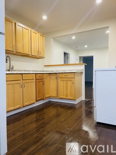 A kitchen with wooden cabinets and a white fridge.