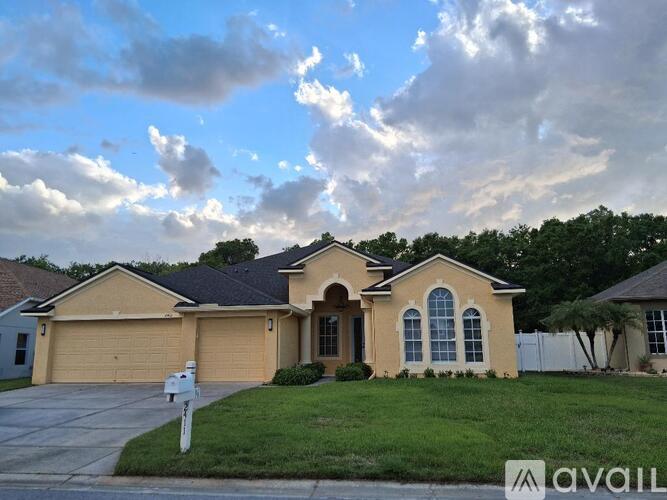 A house with a beige exterior and a black roof is for sale.