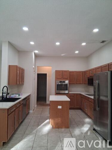 A kitchen with wooden cabinets and a refrigerator.