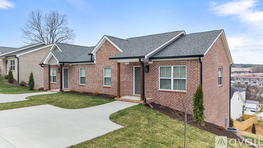 A brick house with a black roof and a white door.