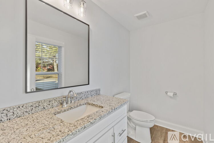 A bathroom with a granite countertop and a large mirror.