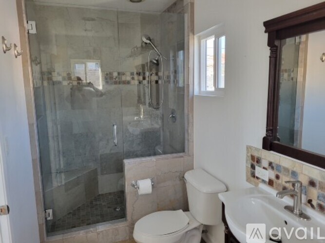A bathroom with a toilet, sink, and shower.