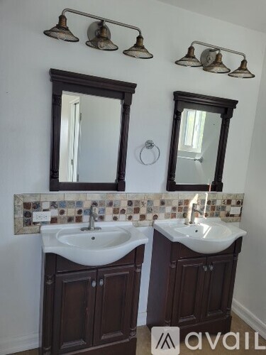A bathroom with two sinks and two mirrors.