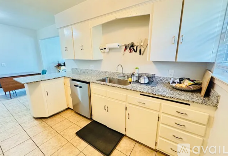 A kitchen with white cabinets and a granite countertop.