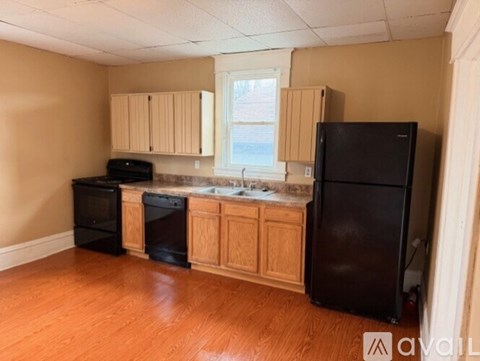A kitchen with wooden cabinets and black appliances.
