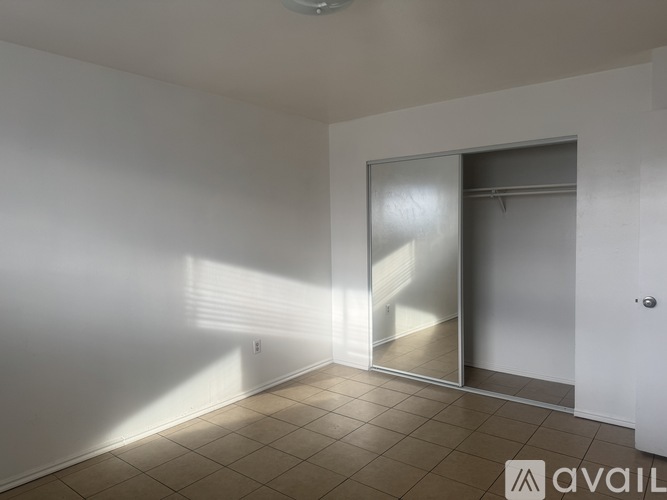 A room with a sliding glass door and tiled floor.