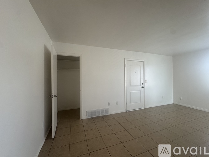 A room with a tiled floor and two doors, one of which is open.
