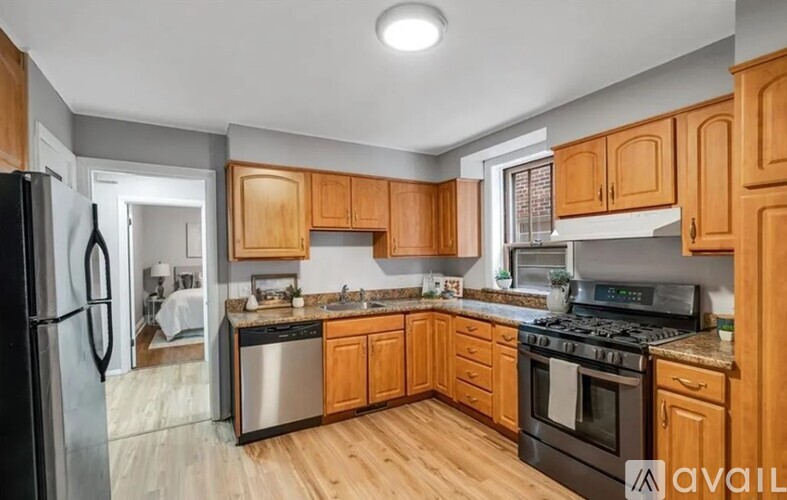 A kitchen with wooden cabinets and stainless steel appliances is available for rent.