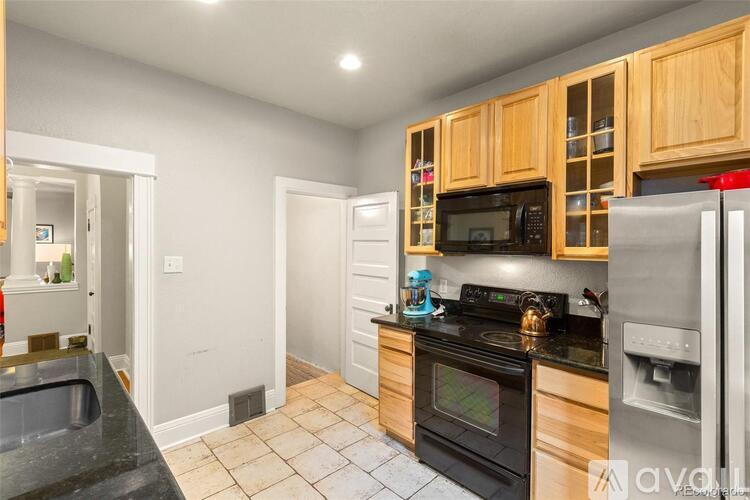 A kitchen with wooden cabinets and black countertops.