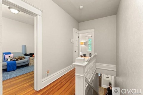 A living room with a couch and a staircase.