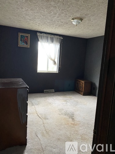 A room with a window and a picture on the wall.