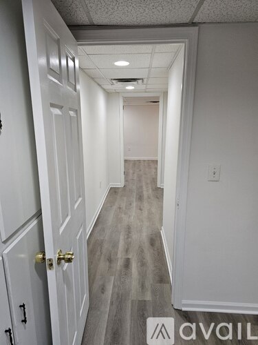 A hallway with a carpeted floor and white walls.