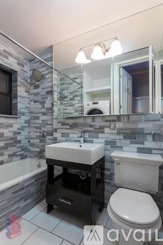 A bathroom with a sink, toilet and a mirror.