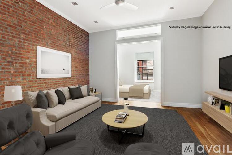 A living room with a brick wall and a white couch.