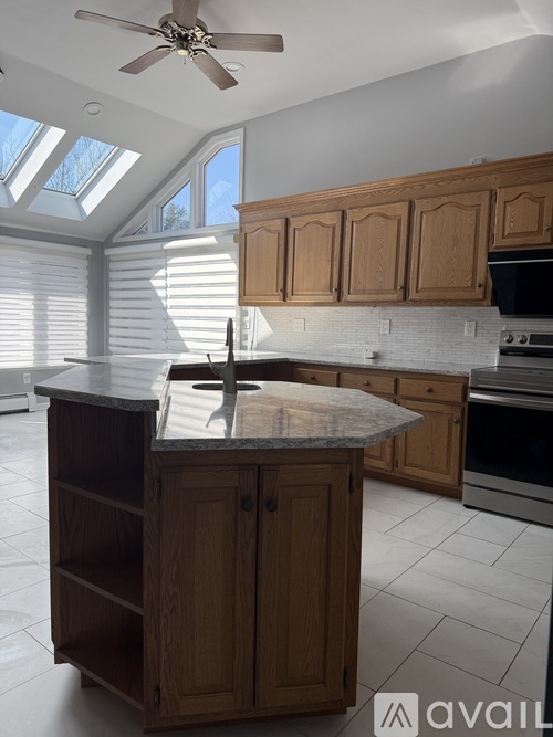 A kitchen with a marble countertop and wooden cabinets.