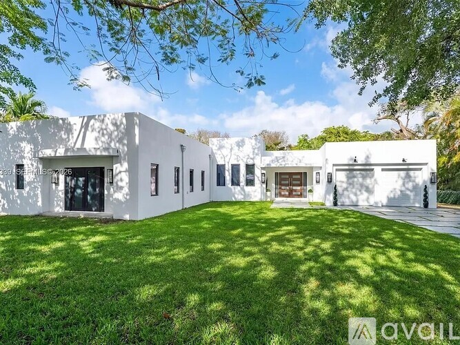 A white building with a green lawn in front.