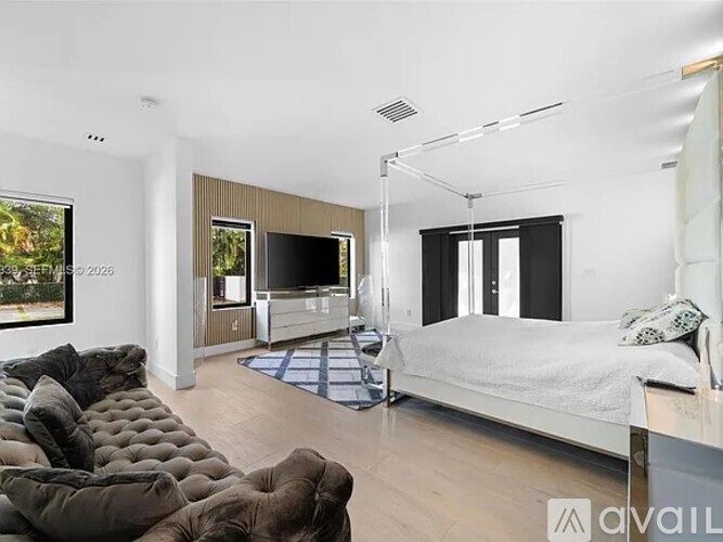 A modern bedroom with a large bed and a television in the corner.