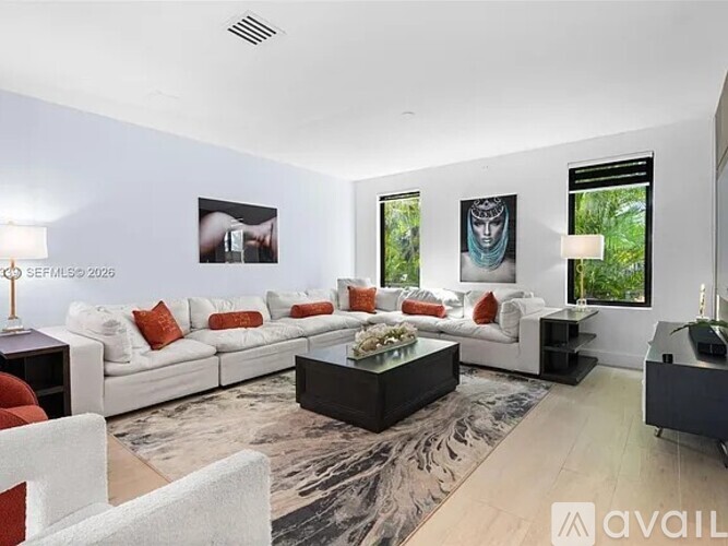 A modern living room with a white sofa set and a coffee table.