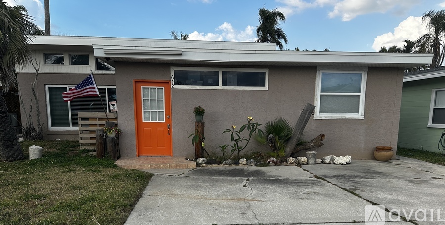 A house with a red door and a flag on the left.