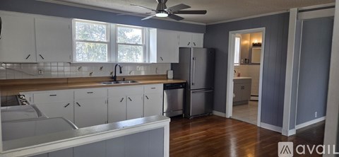 A kitchen with white cabinets and a wooden countertop.