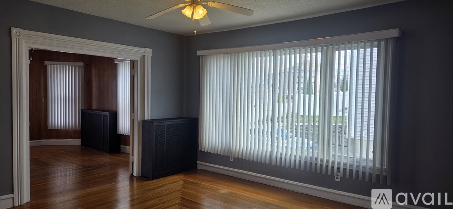 A room with a ceiling fan and a window with blinds.