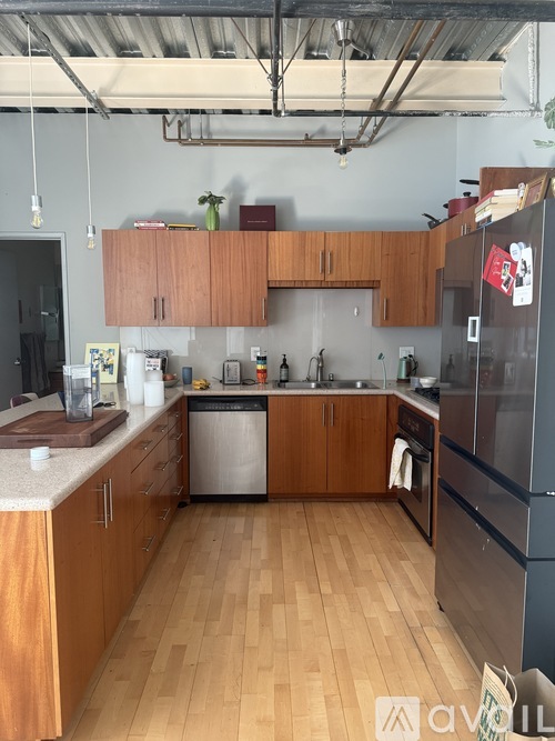 A kitchen with wooden cabinets and a black fridge.