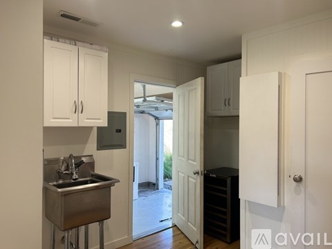 A kitchen with white cabinets and a stainless steel sink.