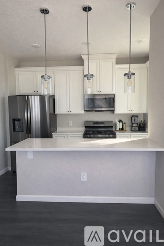 A kitchen with a white island and stainless steel appliances.