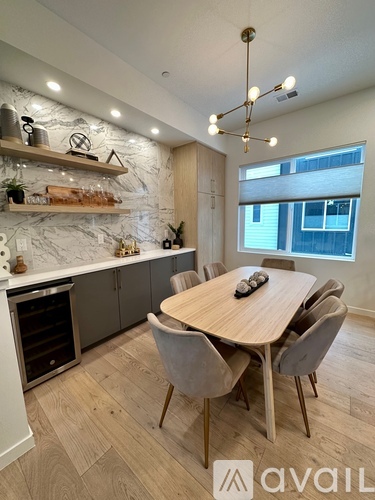 A modern dining room with a wooden table and chairs.