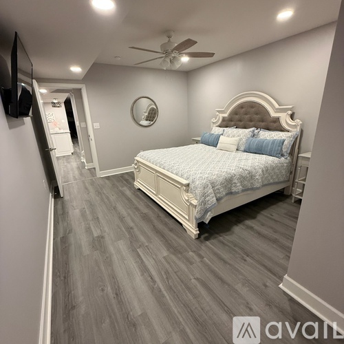 A bedroom with a large bed and a ceiling fan.
