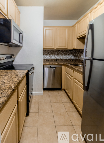 A kitchen with a black fridge and a black microwave.