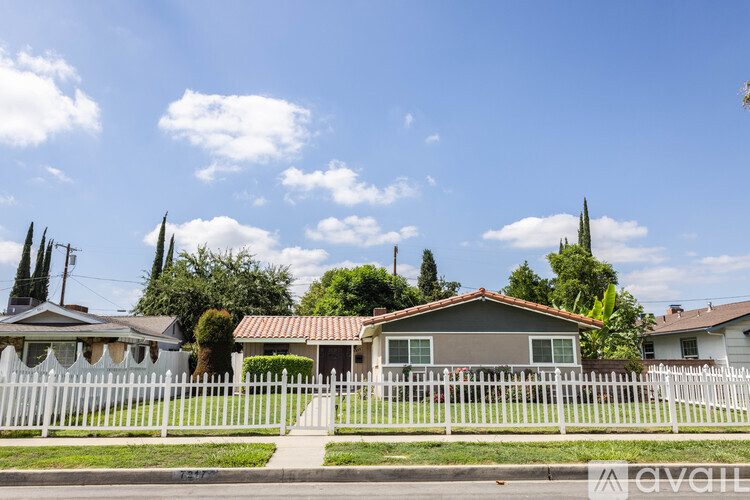 A house with a white picket fence in front of it.