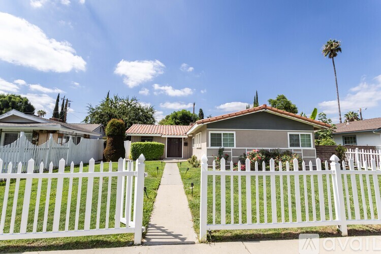 A house with a white picket fence in front.