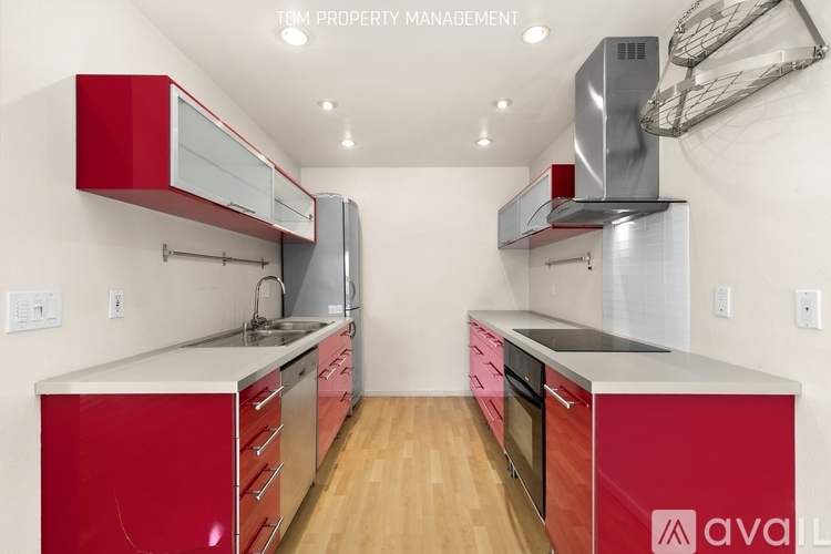 A kitchen with red cabinets and stainless steel appliances.
