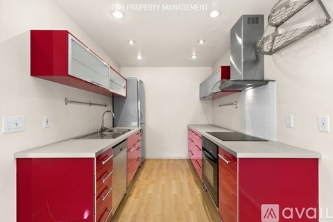 A kitchen with red cabinets and stainless steel appliances.