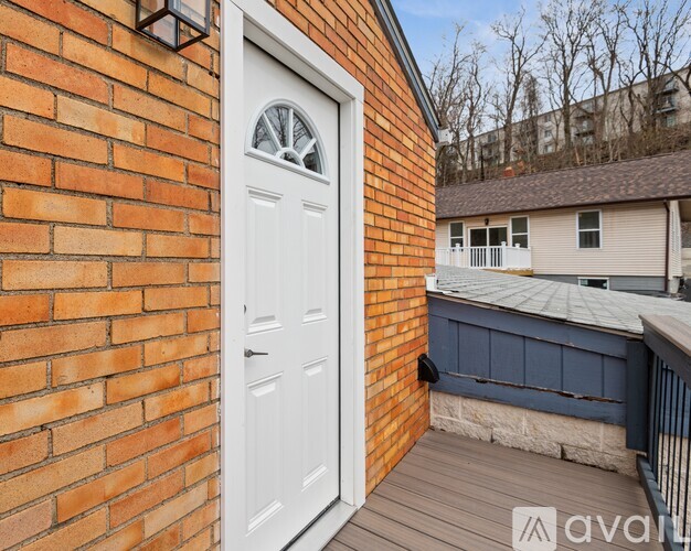 A white door with a glass window is set in a brick wall.