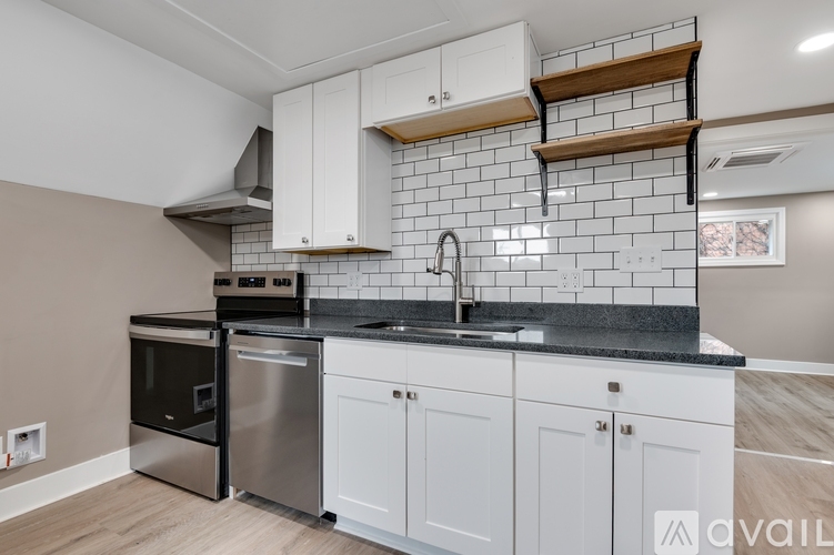 A kitchen with white cabinets and a black countertop.
