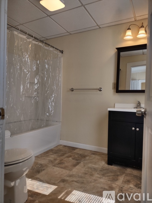 A bathroom with a toilet, sink, and shower.
