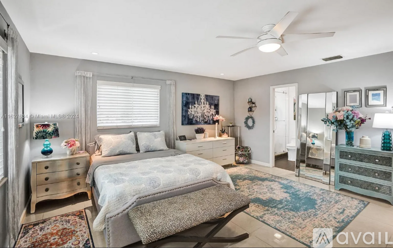 A bedroom with a bed, dresser, and mirror.