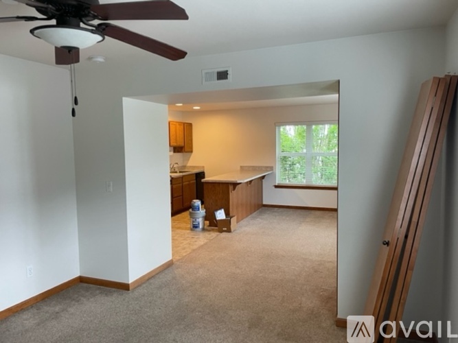 A room with a ceiling fan and a carpeted floor.