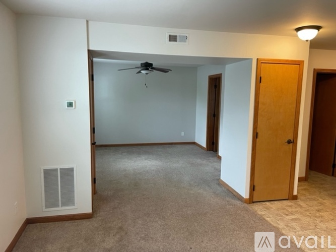 A room with a ceiling fan and carpeted floor.