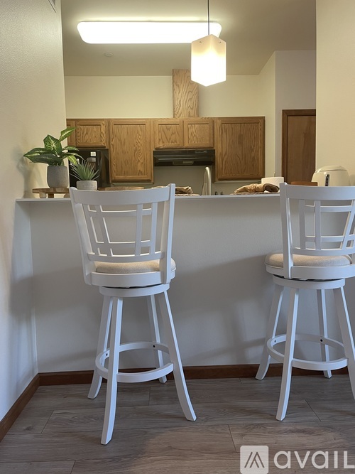 Two white barstools are placed in front of a kitchen island.